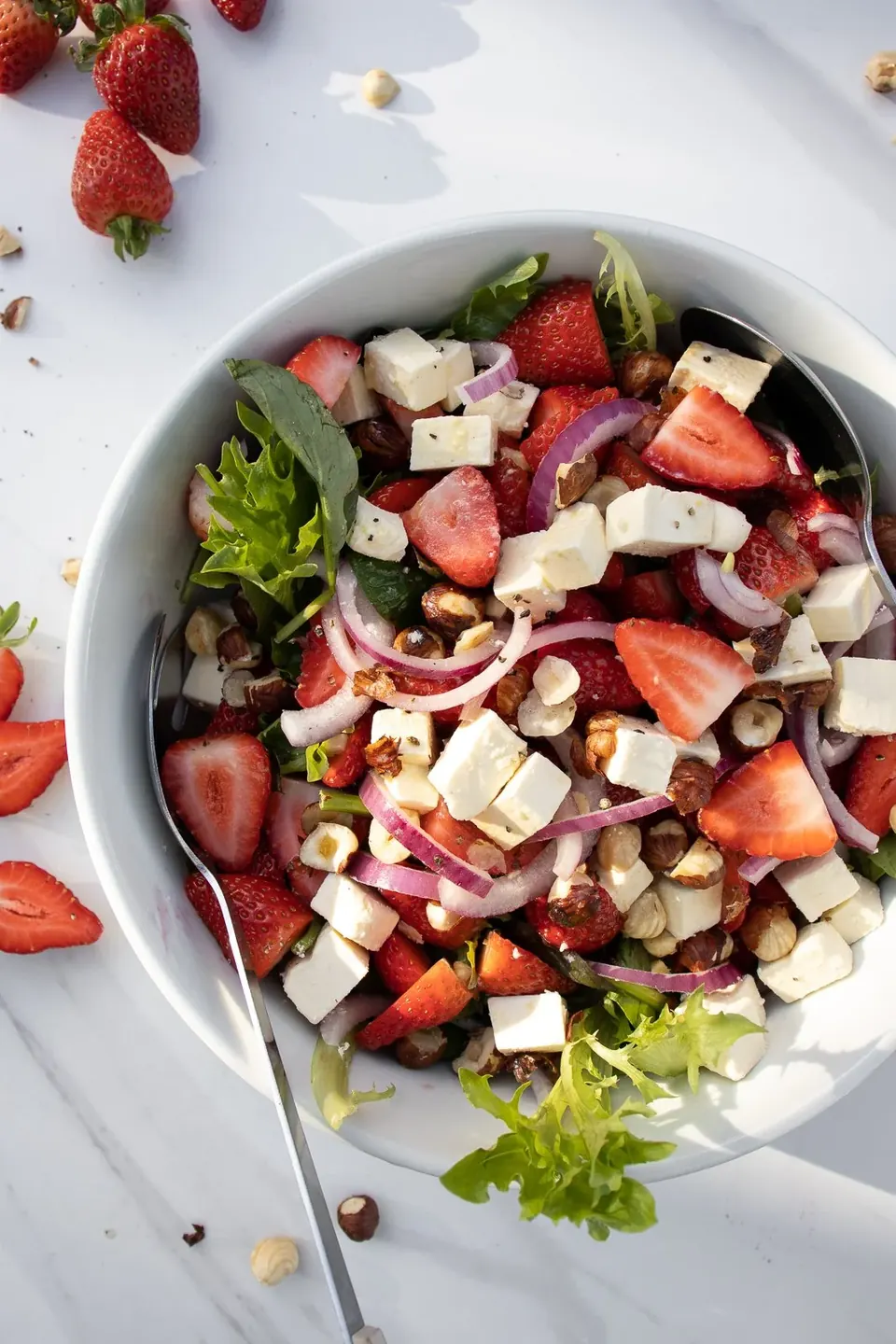 Strawberry salad with feta, red onion, hazelnuts, and mixed greens