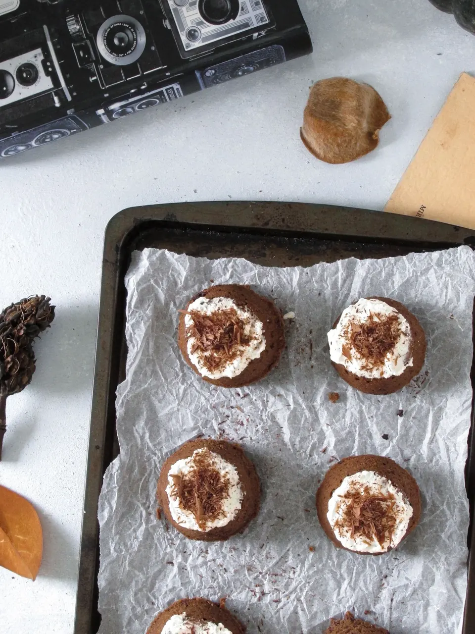 Chocolate pudding cakes topped with whipped cream on a baking tray