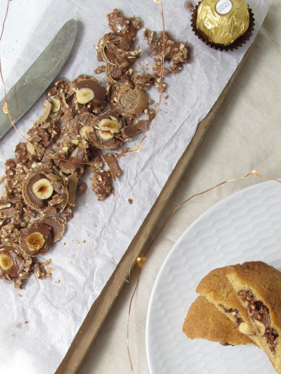Ferrero Rocher cookie and chopped chocolates on parchment-lined board