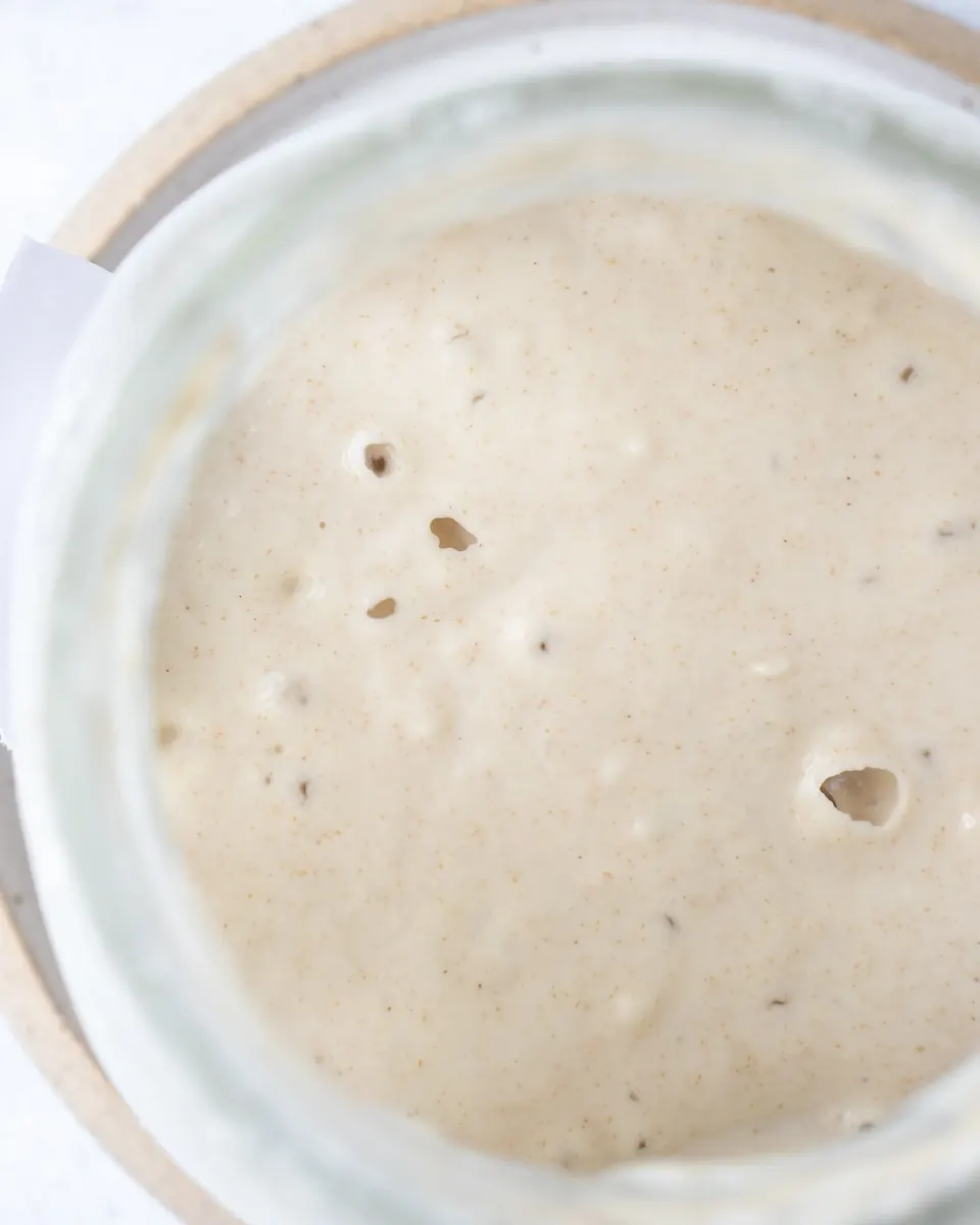 Close-up of bubbly sourdough starter in a glass jar