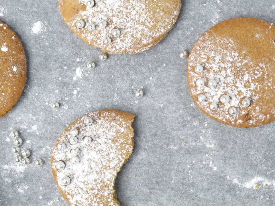Powdered sugar cookies with silver dragees on parchment paper