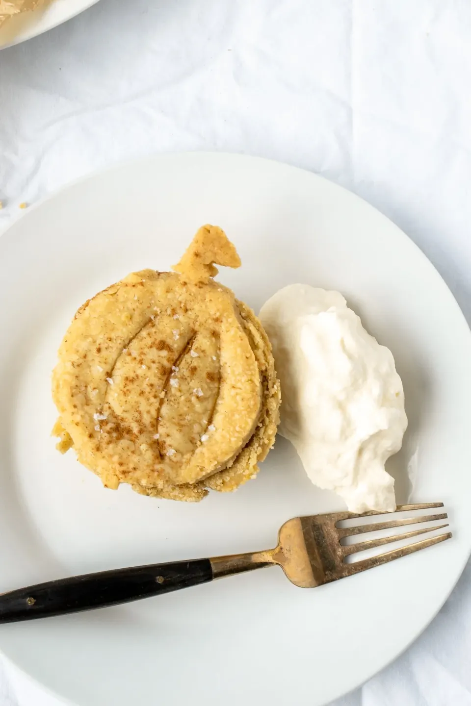 Mini pumpkin pie with whipped cream on a white plate