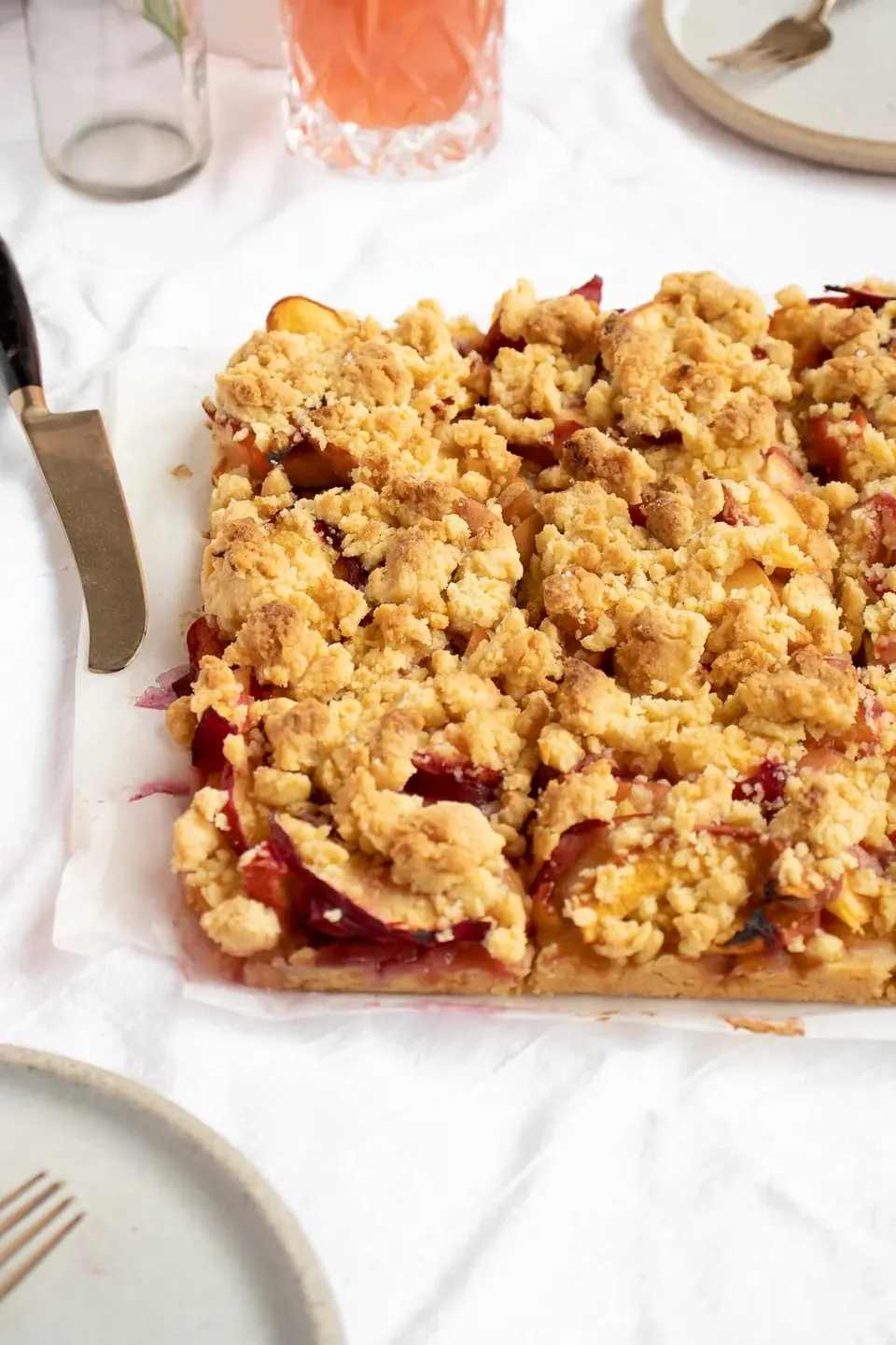 Peach crumble bars with chunky streusel topping on parchment