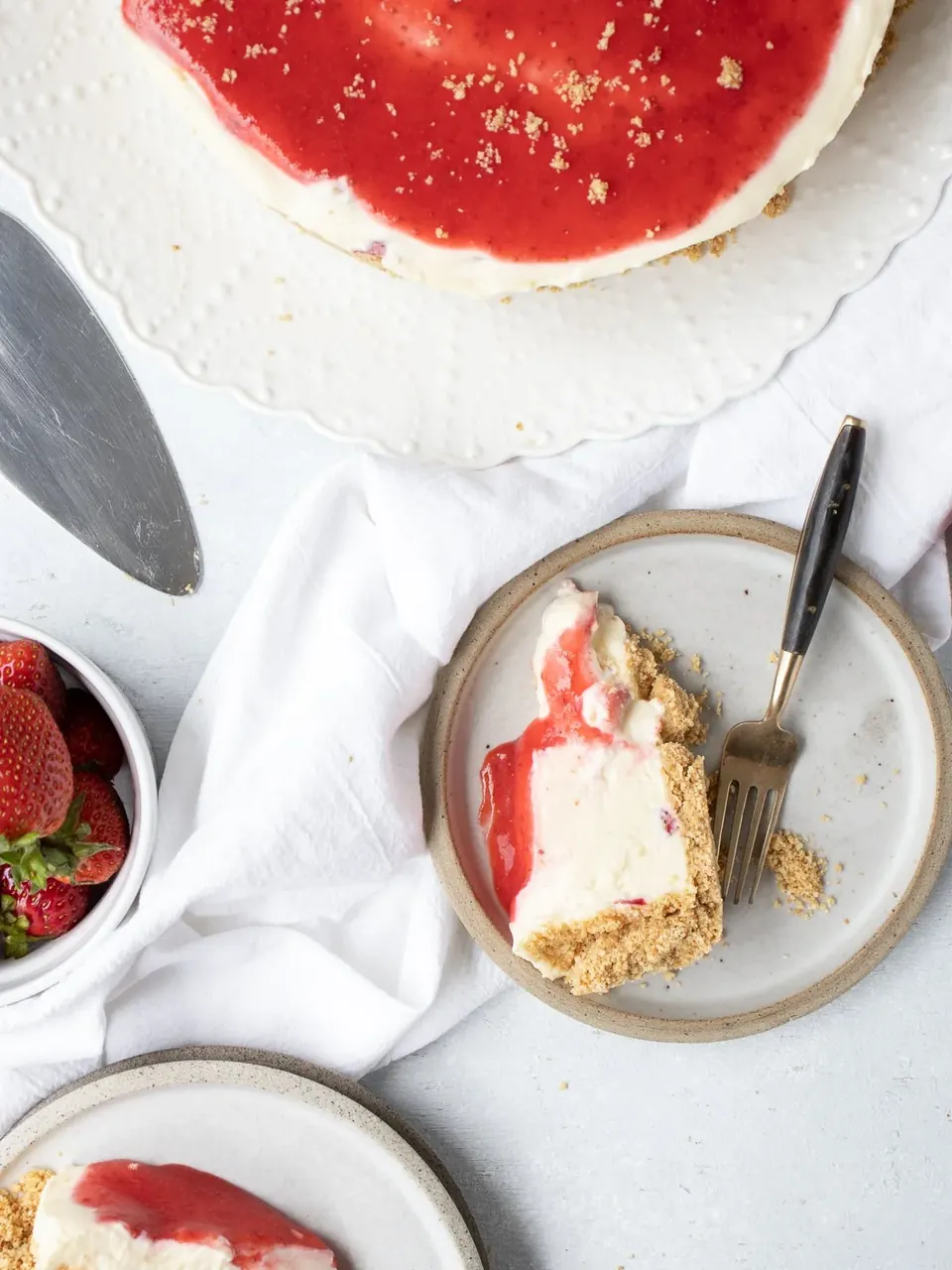 No-bake strawberry cheesecake with sliced piece and fresh strawberries