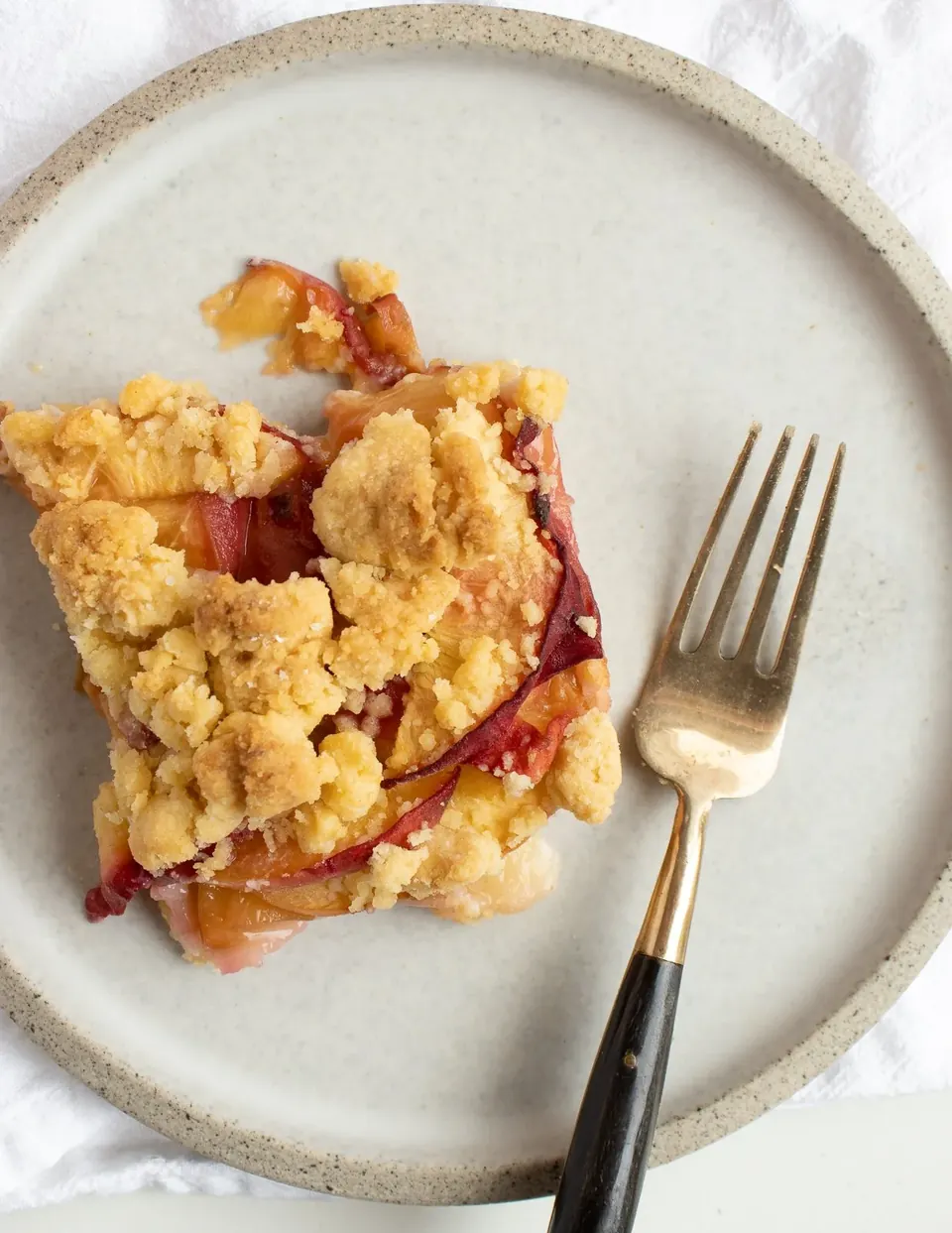 one slice of peach crumble bar on a plate