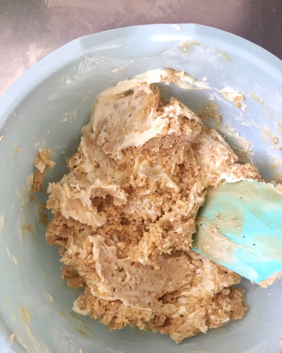 Cream cheese cookie dough mixed in a bowl with spatula