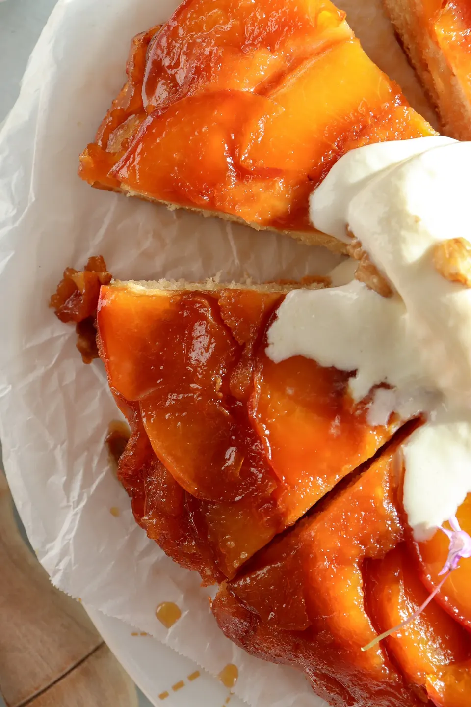 Slices of glossy peach tarte tatin cake with whipped cream