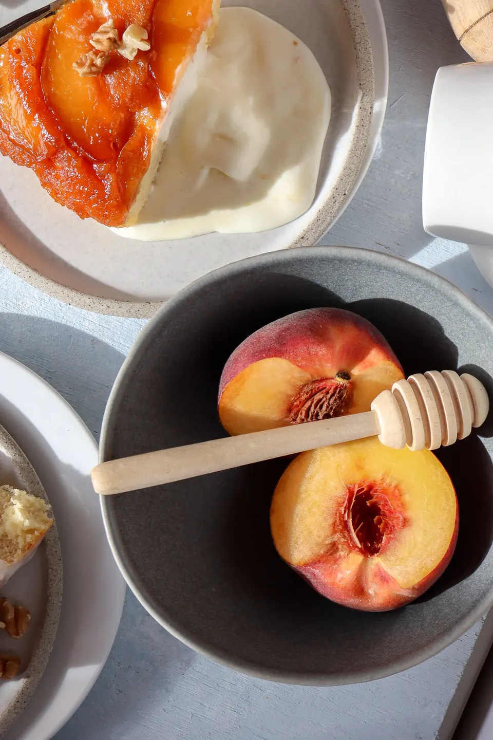 Slice of peach tarte tatin cake with cream and fresh peaches