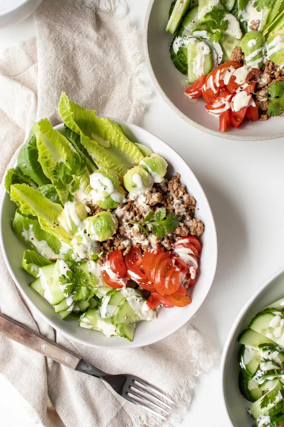 Burger chopped salad bowls with lettuce, avocado, tomato, and creamy dressing