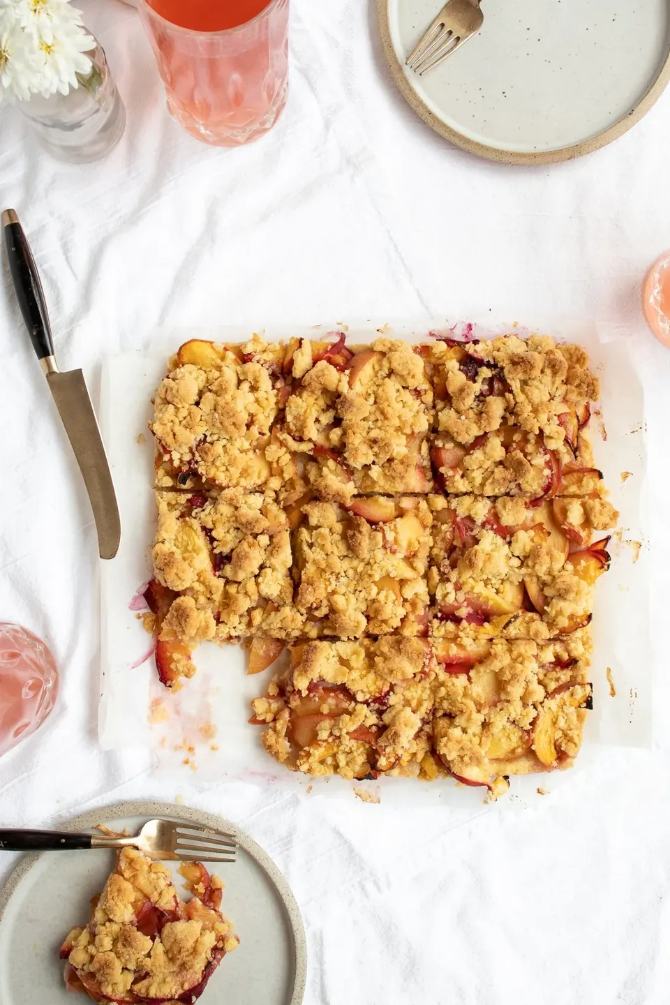 Overhead view of sliced peach crumble bars on parchment