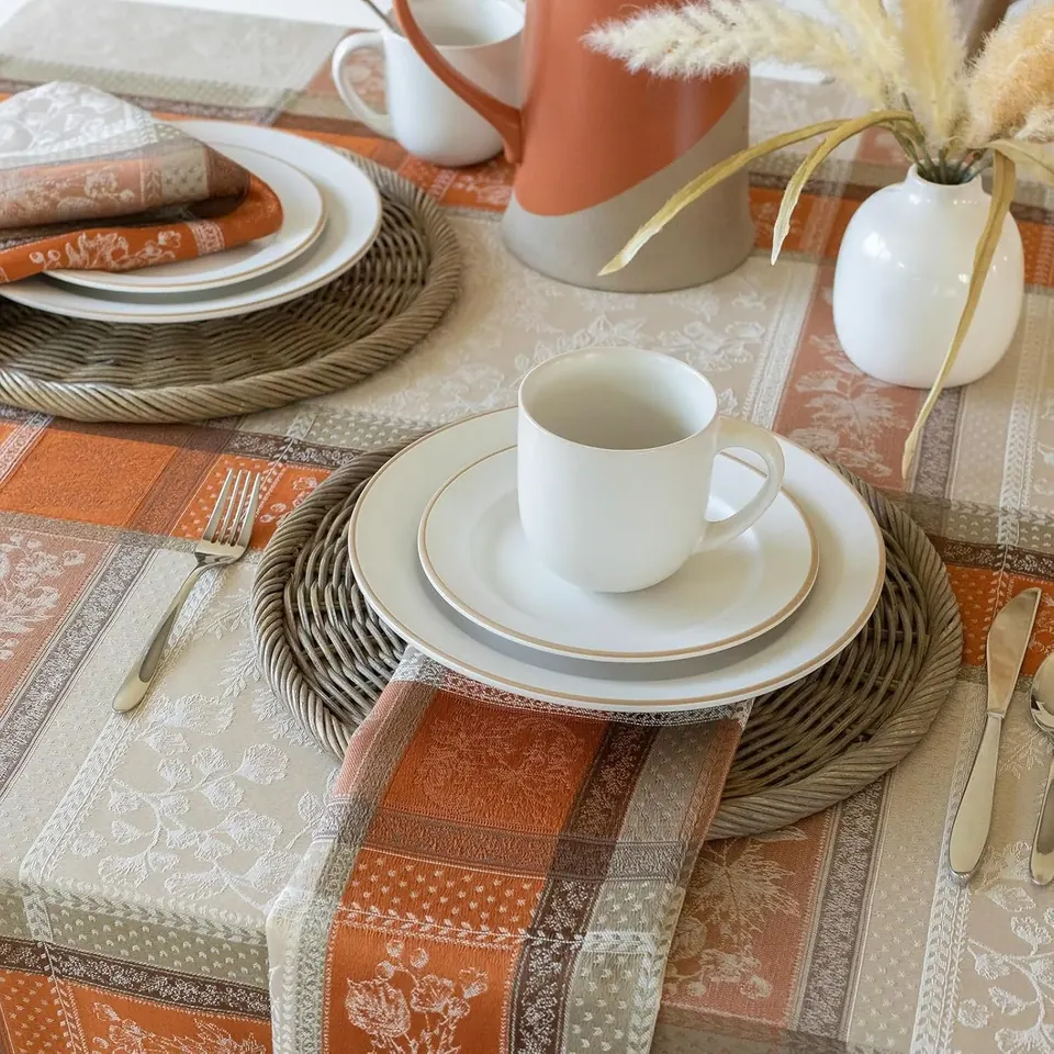 Elegant Thanksgiving table setting with white dishes and autumn-toned linens