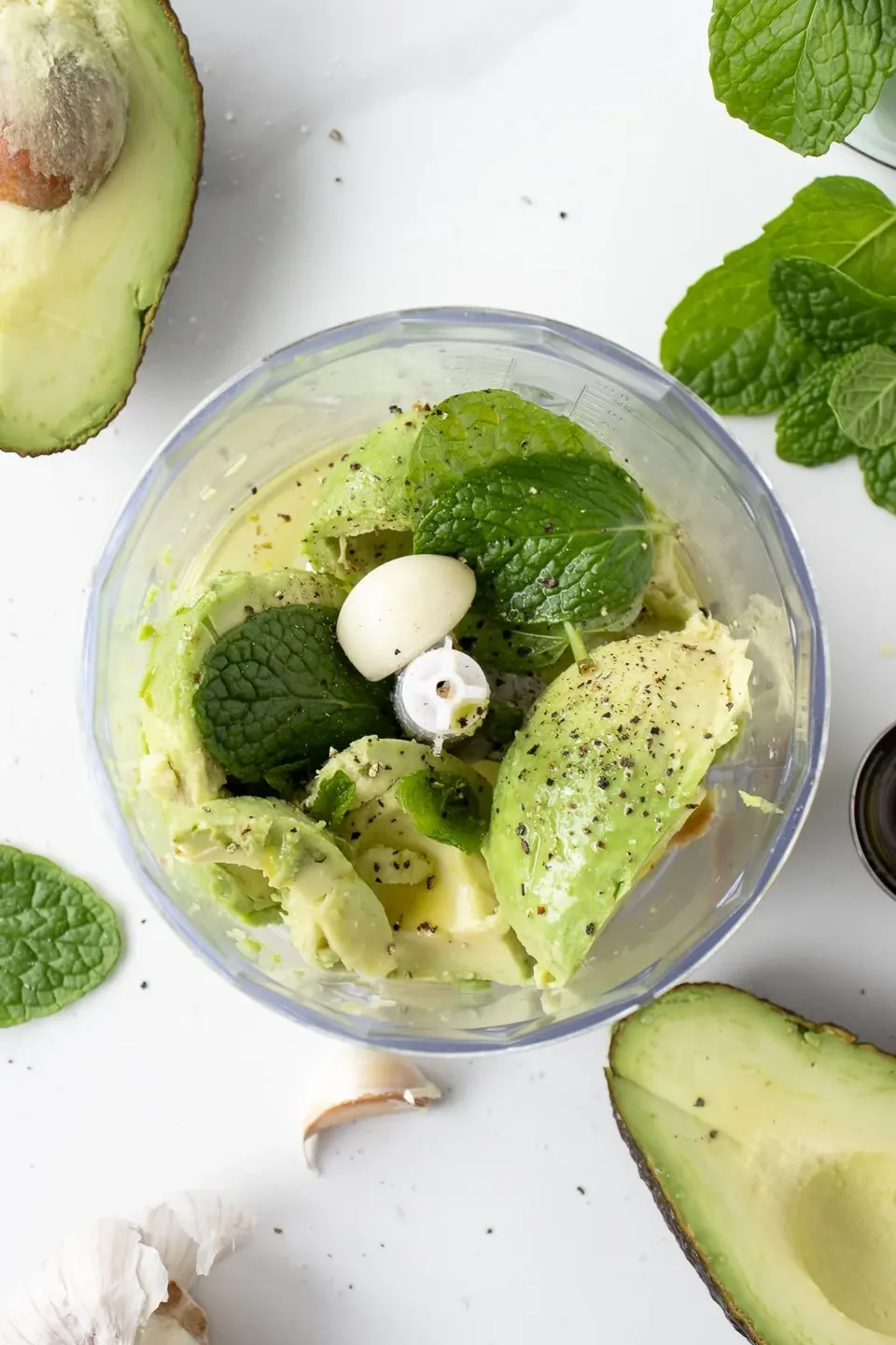 Avocado, mint, garlic, and pepper in a food processor