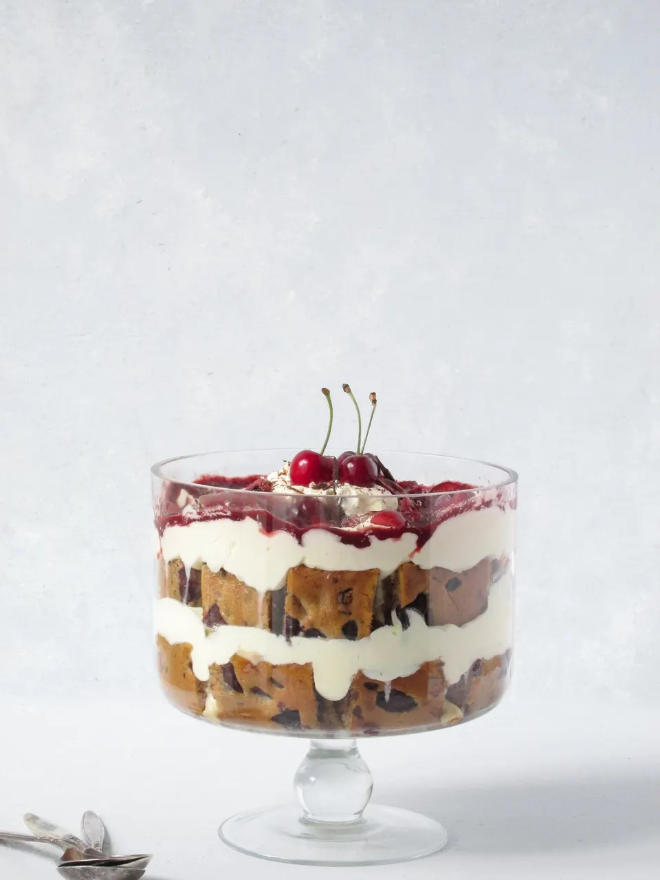 Cherry cake trifle layered with custard in a glass bowl