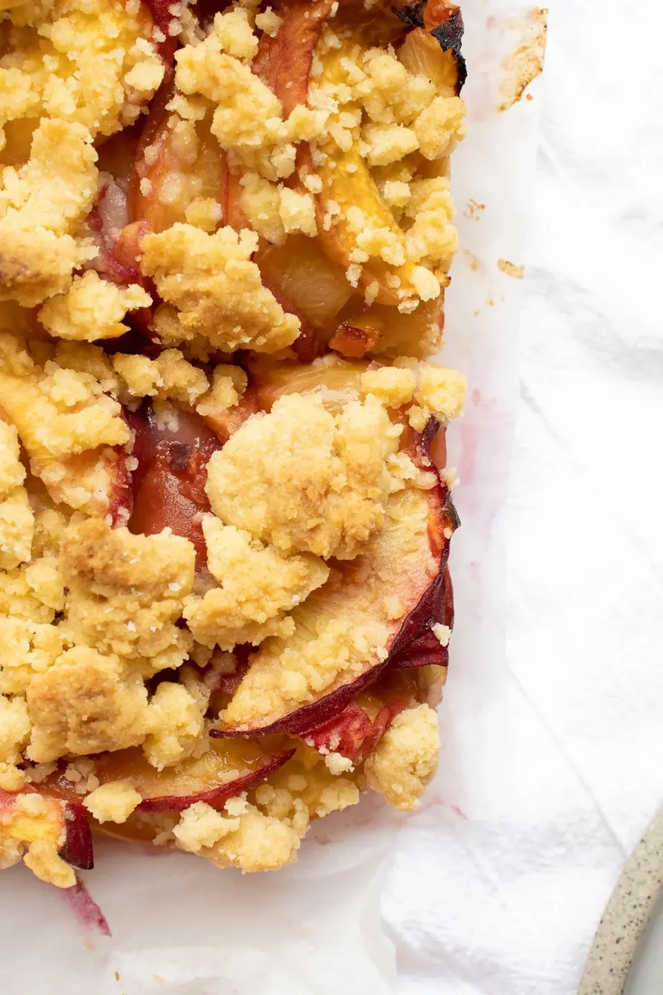 Close-up of peach crumble bars with golden buttery streusel topping