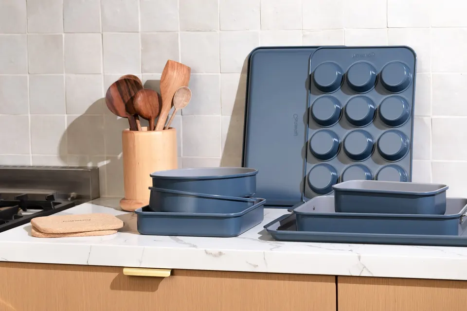 Blue Caraway bakeware set arranged on a kitchen countertop